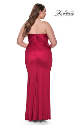 A woman is shown from the back against a white background wearing the La Femme Plus-Size Long Tube Prom Dress 32194. This strapless, fitted, floor-length red gown features side ruching and a zipper closure.