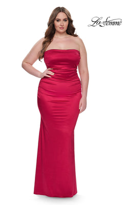 A woman models the La Femme Plus-Size Long Tube Prom Dress 32194 in deep red, a strapless, form-fitting, floor-length gown, standing against a white background with the La Femme logo in the top right corner.
