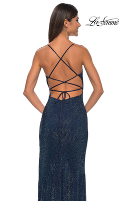 A woman wearing the La Femme Embellished Long Fishnet Prom Dress 32203 with crisscross open-back straps and a subtle shimmer stands against a white background.