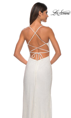 A woman wears the La Femme Embellished Long Fishnet Prom Dress 32203, a white textured gown with an open back, crisscross and tie-up straps; "La Femme" logo appears in the upper right corner.