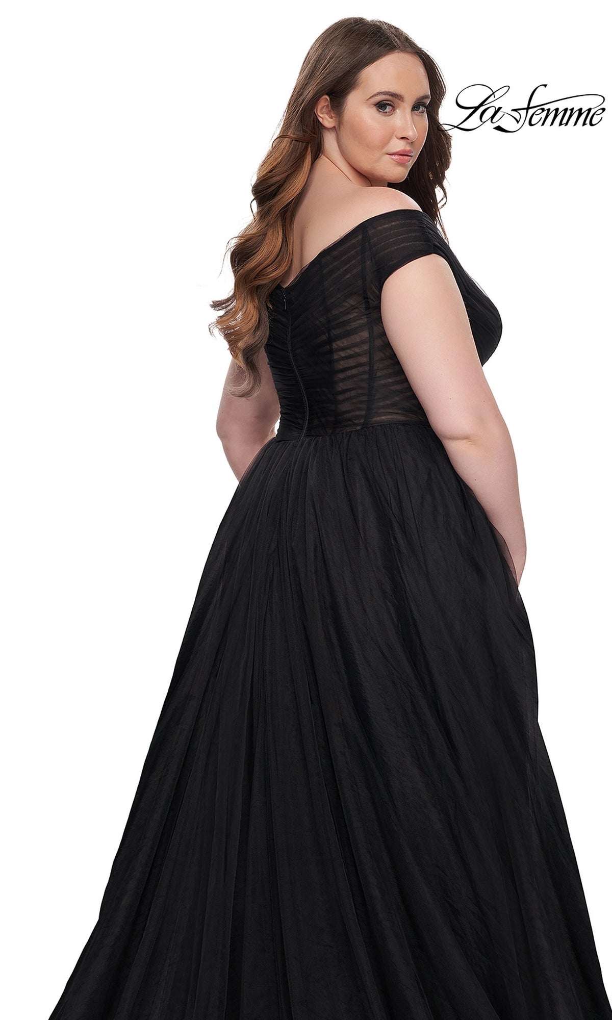 Woman models the La Femme Plus-Size Long A-Line Prom Dress 32204, a floor-length black off-the-shoulder gown with sheer bodice detailing, against a white background. 