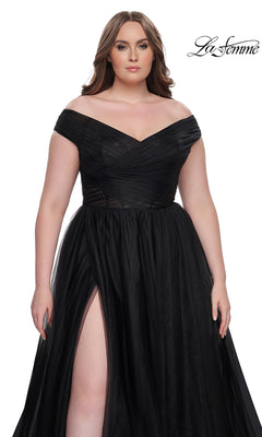 A woman models the La Femme Plus-Size Long A-Line Prom Dress 32204—a black, floor-length gown with off-the-shoulder sleeves and a thigh-high slit—against a white backdrop with the La Femme logo.