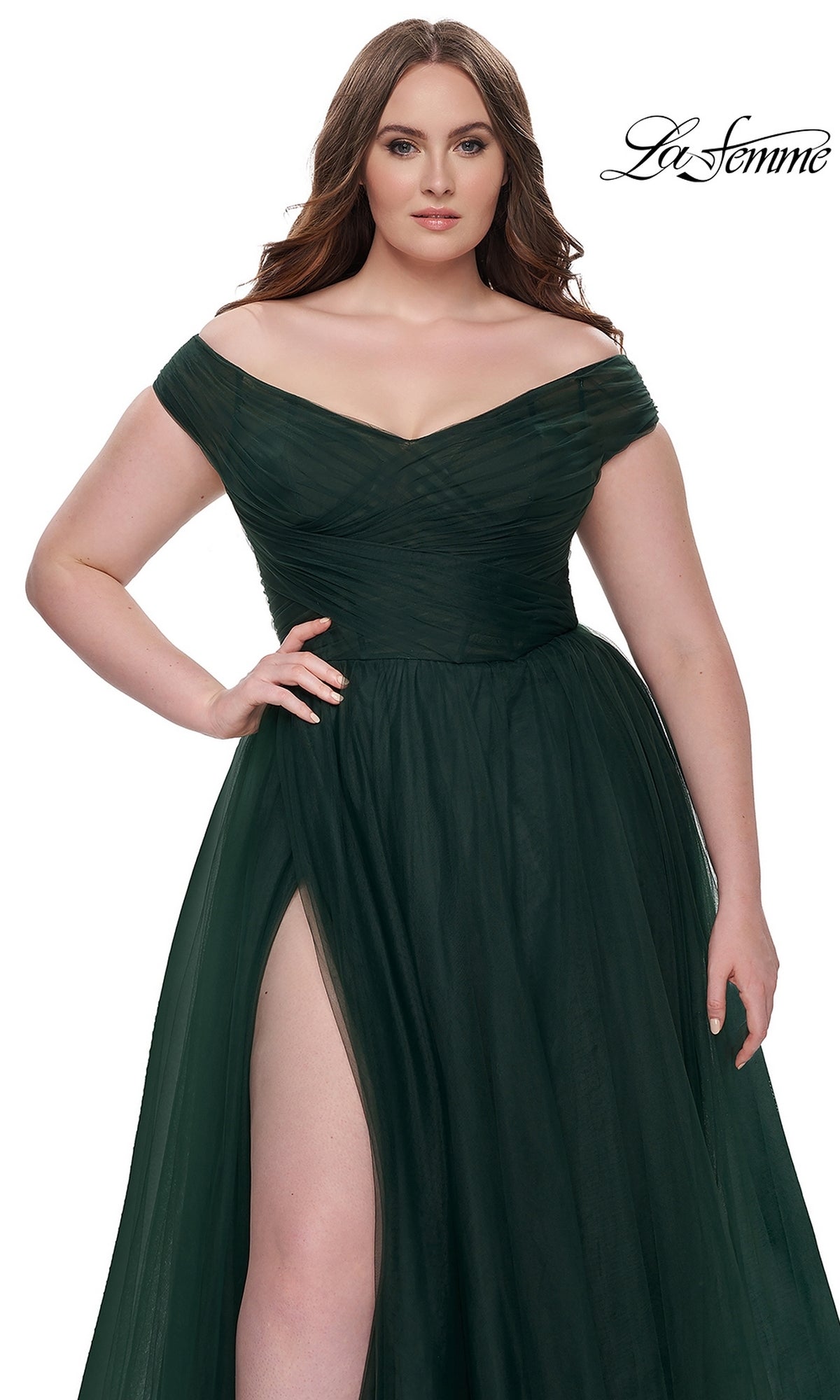 A woman models the La Femme Plus-Size Long A-Line Prom Dress 32204 in dark green, featuring an off-the-shoulder neckline, ruched bodice, and high slit, against a white background with the 