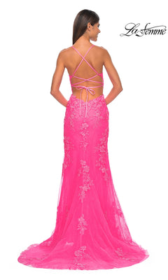 Woman in a bright pink La Femme Embroidered-Lace Long Prom Dress 32205 with floral lace and a crisscross open back, looking away. "La Femme" appears in the top right corner.