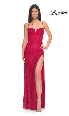A woman wears the La Femme Long Bustier Fishnet Prom Dress 32210, a fitted, sparkly red gown with spaghetti straps, a V-neckline, and a high leg slit. She stands against a white backdrop with the "La Femme" logo in the top right corner.