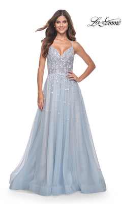 A woman wears the La Femme Embellished Long A-Line Prom Dress 32215, featuring sequins, thin straps, and a flowing light blue tulle skirt, while standing against a plain white background.