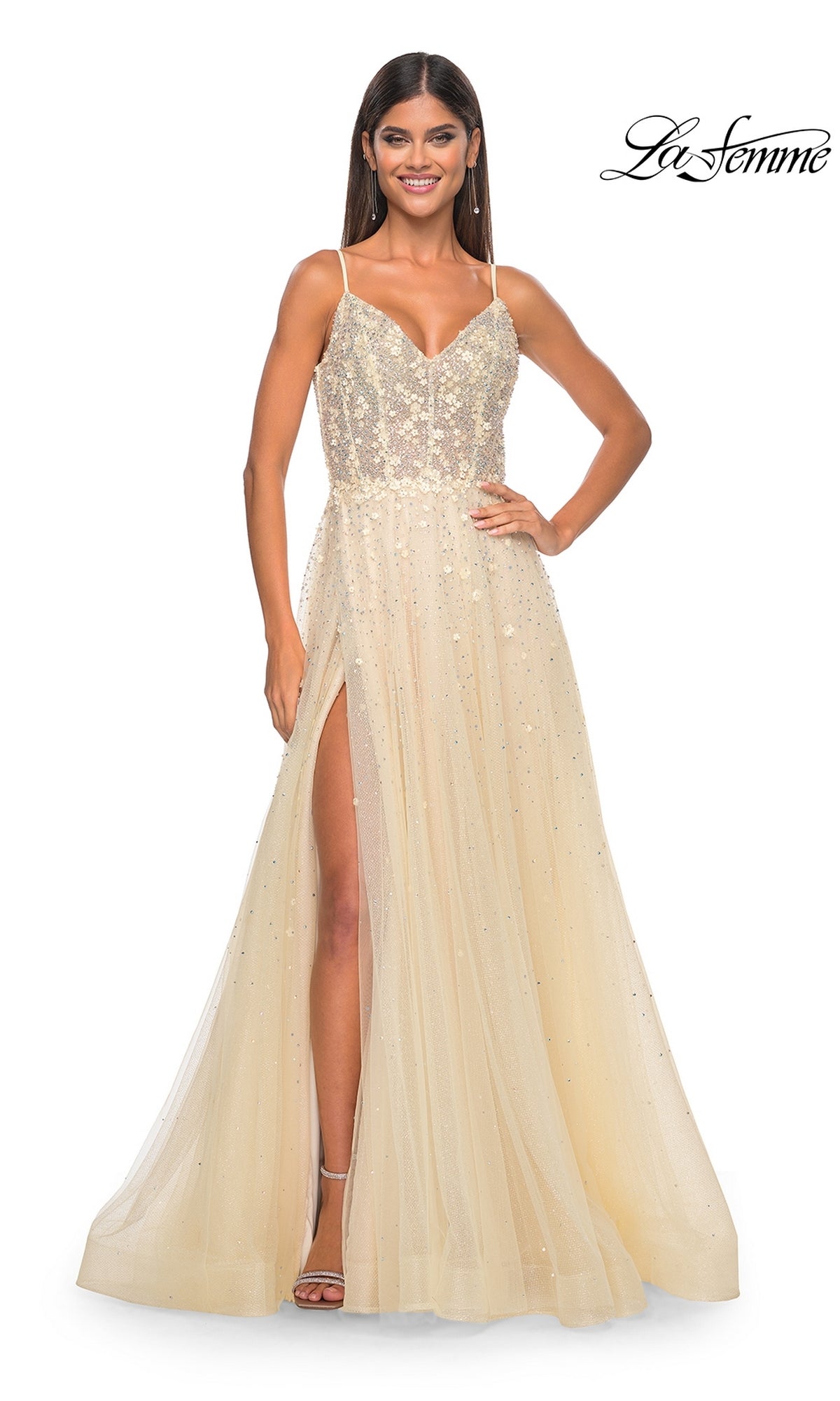 A woman wearing the La Femme Embellished Long A-Line Prom Dress 32215, a sleeveless light gold gown with thin straps, a V-neckline, and a high slit.