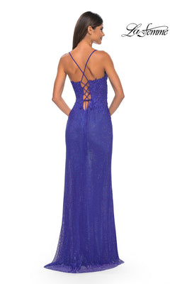 A woman in a purple La Femme Rhinestone Fishnet Long Prom Dress 32218 with thin crisscross straps and a lace-up back stands facing away. The La Femme logo appears in the top right corner.
