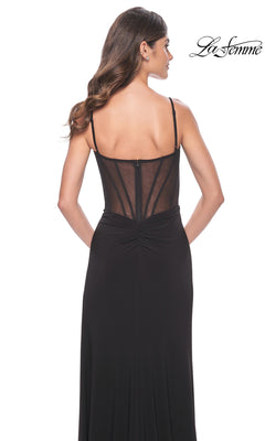 A woman is seen from behind wearing the La Femme Sexy Long Black Prom Dress 32220, featuring thin straps and a sheer, corset-style bodice with boning details. The "La Femme" logo appears in the top right on a white background.