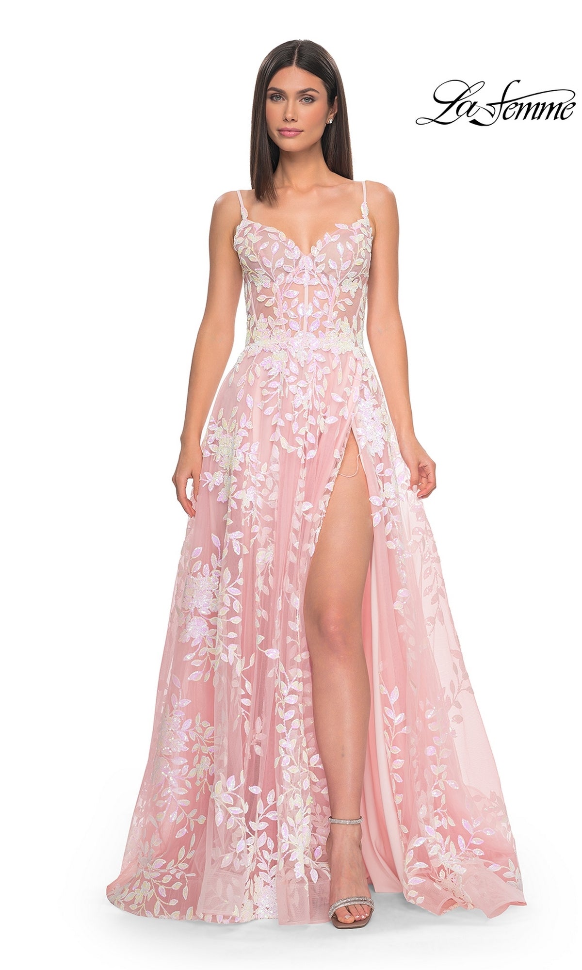 A woman models the La Femme Sequin-Print Long A-Line Prom Dress 32223—a light pink gown with floral embroidery, thigh-high slit, and thin straps—against a white backdrop. The La Femme logo appears in the top right corner.