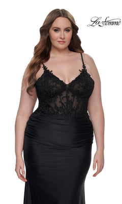 Woman in a La Femme Plus-Size Long Black Prom Dress 32226 with an embroidered-lace bodice and thin straps, standing against a plain white background.