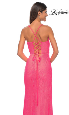A woman stands with her back to the camera in a pink La Femme Sheer Bustier Long Prom Dress 32227, featuring a sleeveless design, lace-up back, thin crisscross straps, and a subtle textured pattern.