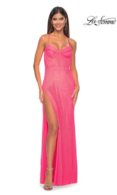 A woman smiles in the La Femme Sheer Bustier Long Prom Dress 32227 in Neon Pink, featuring spaghetti straps, a sweetheart neckline, mesh details, and a high slit. La Femme logo appears in the top right corner.