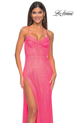 Woman wearing the La Femme Sheer Bustier Long Prom Dress 32227 in bright pink, featuring thin straps, a sheer bodice with visible boning, and a high slit. She poses and smiles against a white background with the "La Femme" logo in the corner.