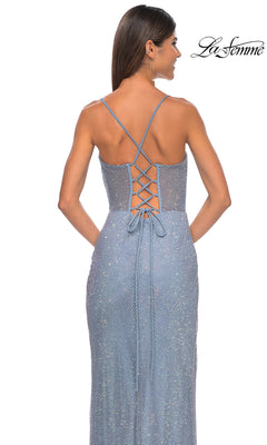 A woman models the La Femme Sheer Bustier Long Prom Dress 32227, featuring a sparkly light blue fabric, thin straps, and lace-up back design, against a plain white background.