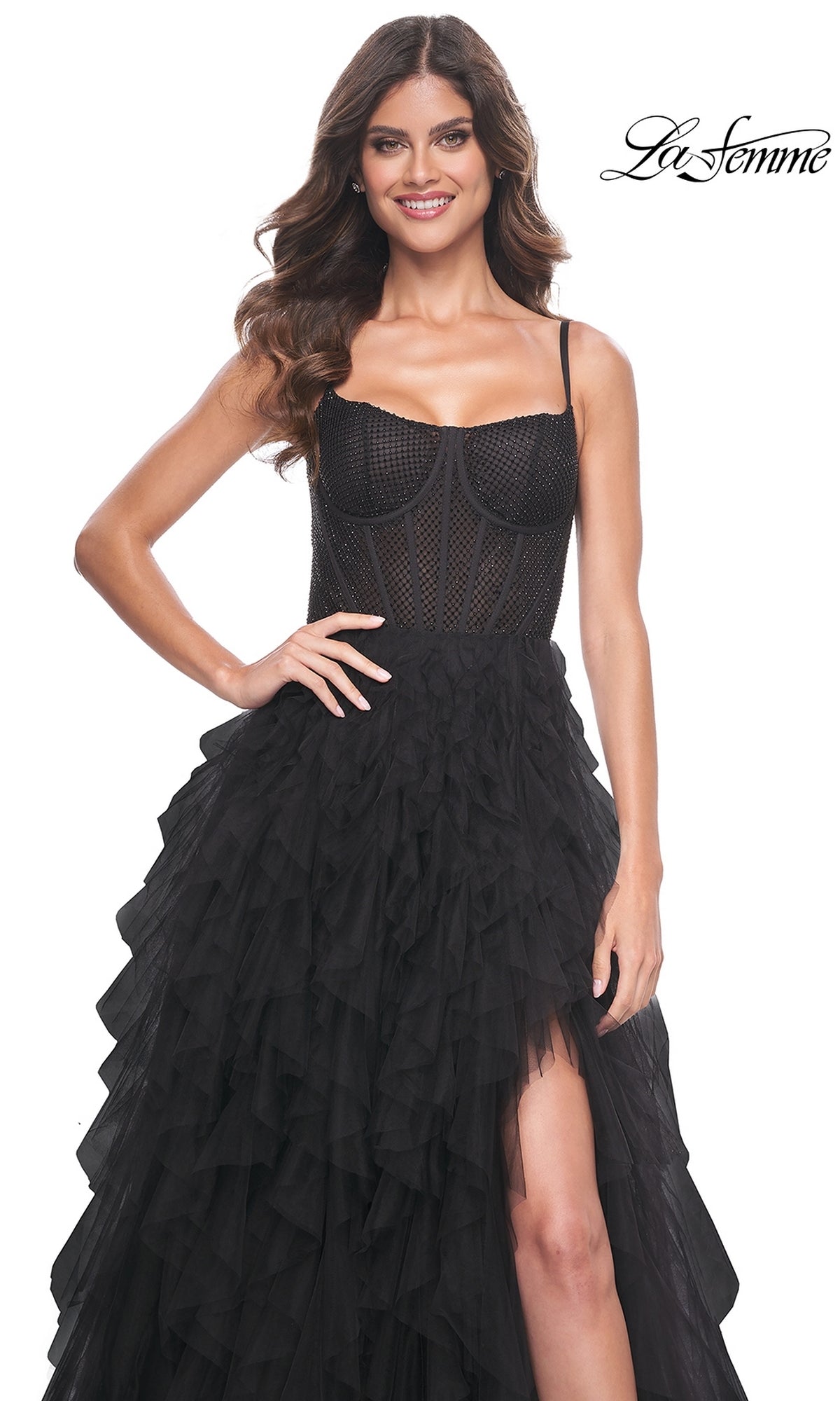 A woman wears the La Femme Sheer-Waist Long Ruffled Prom Dress 32233, featuring a black sleeveless design with a fitted mesh bodice and tiered ruffled skirt, standing against a white background.