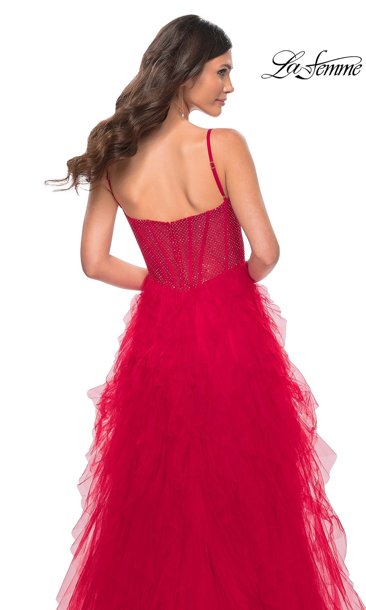 Woman wearing a red La Femme Sheer-Waist Long Ruffled Prom Dress 32233 with beaded bodice and layered tulle skirt, viewed from the back. The La Femme logo appears in the top right corner.