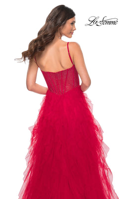 Woman wearing a red La Femme Sheer-Waist Long Ruffled Prom Dress 32233 with beaded bodice and layered tulle skirt, viewed from the back. The La Femme logo appears in the top right corner.