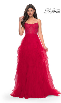 A woman in a sleeveless red La Femme Sheer-Waist Long Ruffled Prom Dress 32233 with beaded details and fitted bodice poses against a white background. A layered tulle skirt adds elegance; the La Femme logo appears at the top right.