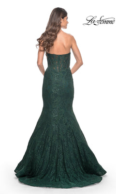 A woman models the La Femme Strapless Long Mermaid Prom Dress 32249 in dark green, featuring a fitted bodice and flared floor-length skirt, shown from the back.