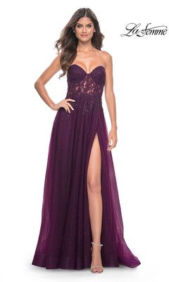 A woman poses confidently in the La Femme Sheer-Lace Long Beaded Prom Dress 32253—a strapless deep purple A-line gown featuring a sheer lace bodice, thigh-high slit, and slightly sparkly flowing skirt.