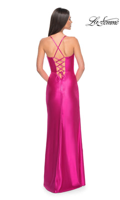 A woman faces away, wearing the La Femme Bright Neon Long Prom Dress 32262—floor-length fuchsia satin with a corset bodice, lace-up back, and thin crisscross straps. The "La Femme" logo is in the top right corner.