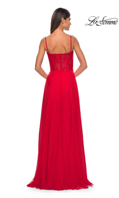 A woman faces away, wearing the La Femme Long Chiffon Sweetheart Prom Dress 32276—a bright red gown with thin straps, a fitted semi-sheer floral lace bodice, and a flowing skirt. The La Femme logo appears in the upper right corner.