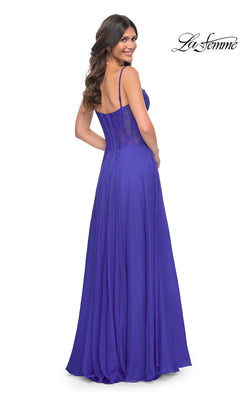 A woman stands looking over her shoulder, wearing the La Femme Long Chiffon Sweetheart Prom Dress 32276—floor-length, royal blue with spaghetti straps and a floral-lace sweetheart bodice.