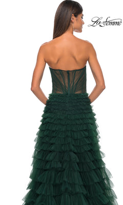 Woman wearing the La Femme Strapless Long Ruffled Prom Dress 32283 in dark green tulle, seen from the back with long straight hair and hoop earrings. La Femme logo displayed in the top right corner.