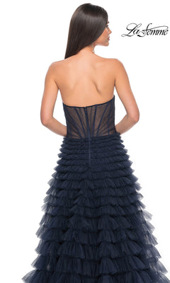 A woman with long straight hair models the La Femme Strapless Long Ruffled Prom Dress 32283, a navy blue a-line gown shown from the back. The La Femme logo appears in the upper right corner.