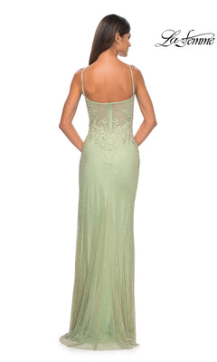 A woman is elegantly shown from the back in the La Femme Embellished Long Fishnet Prom Dress 32292, a light green, floor-length gown with thin straps, intricate lace beading, and a corset-style bodice.