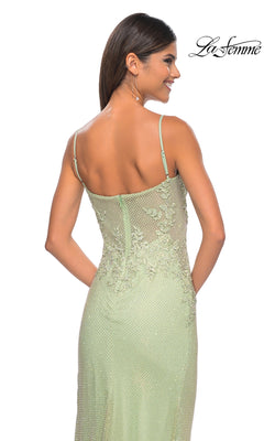 A woman in the La Femme Embellished Long Fishnet Prom Dress 32292 faces away, smiling. The light green gown has thin straps, a corset-style bodice, beaded lace, and detailed back. The La Femme logo is in the upper right corner.