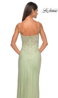 A woman is seen from the back wearing the La Femme Embellished Long Fishnet Prom Dress 32292, a fitted light green formal gown with beaded lace details, sheer overlay, spaghetti straps, and the La Femme logo in the top right corner.