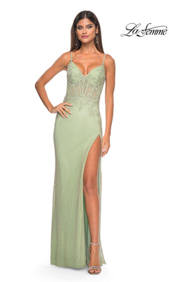 A woman wearing the La Femme Embellished Long Fishnet Prom Dress 32292, a light green, sleeveless gown with beaded lace, thigh-high slit, spaghetti straps, and delicate lace detailing.