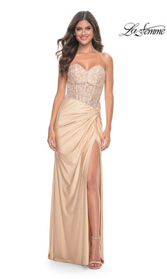 A woman in the La Femme Strapless Long Pleated Prom Dress 32301, featuring a sheer floral-lace bodice and high slit, stands smiling. The La Femme logo is displayed in the top right corner.