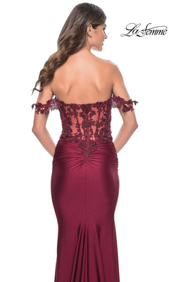 A woman models the La Femme Off-the-Shoulder Long Prom Dress 32302, featuring beaded floral lace and a sheer back, photographed from behind against a white background.
