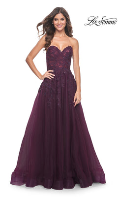Woman wearing the La Femme Lace-Up Long Sweetheart Prom Dress 32304 in deep purple with lace and tulle details, smiling. This elegant strapless A-line gown adds grace. La Femme logo appears in the top right corner.