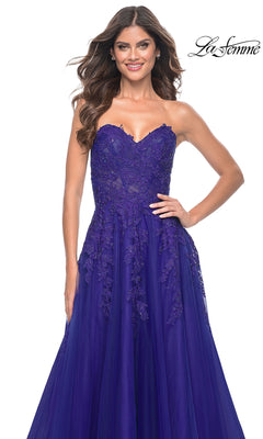A woman stands smiling against a white background, wearing the La Femme Lace-Up Long Sweetheart Prom Dress 32304 in royal blue with lace details. The "La Femme" logo appears in the top right corner.