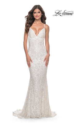 A woman poses against a plain background wearing the La Femme Backless Long Beaded Prom Dress 32309— a sleeveless, white lace, floor-length gown with a deep V-neckline. The La Femme logo is displayed in the top right corner.