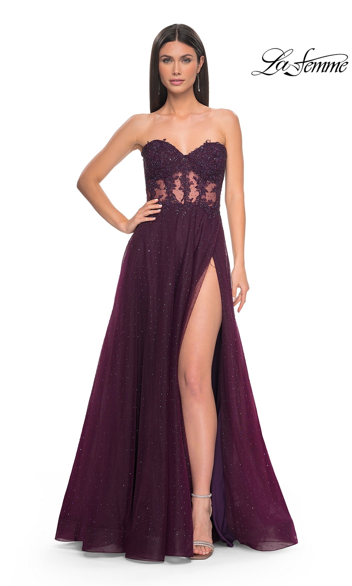 A woman wearing the La Femme Sheer-Waist Long A-Line Prom Dress 32313, a strapless dark purple gown with a beaded lace bodice, sequin accents, and a thigh-high slit.