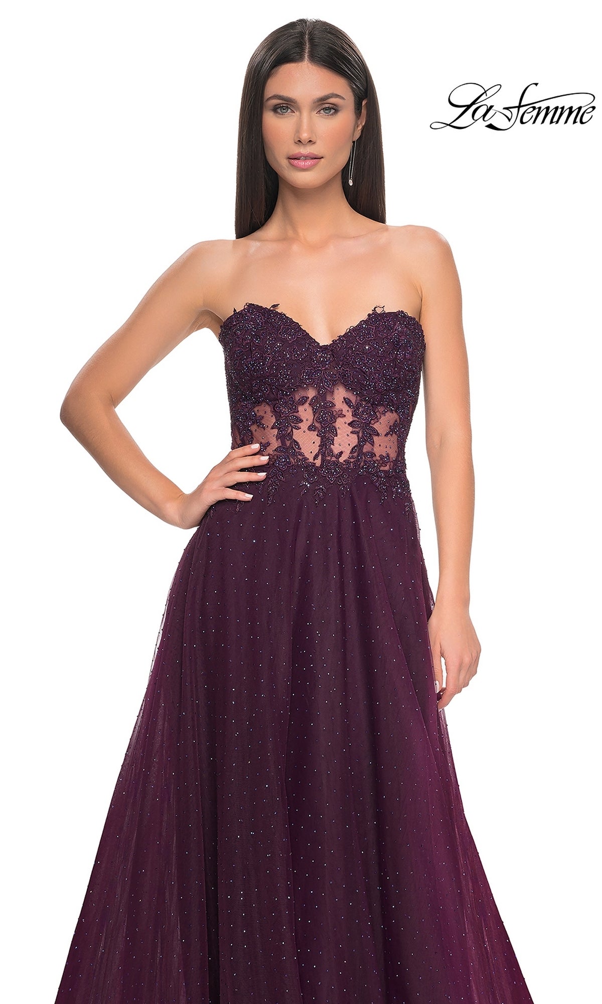 A woman models the La Femme Sheer-Waist Long A-Line Prom Dress 32313 in deep purple, featuring a strapless beaded lace bodice and sheer lace details, as she poses elegantly against a white background.