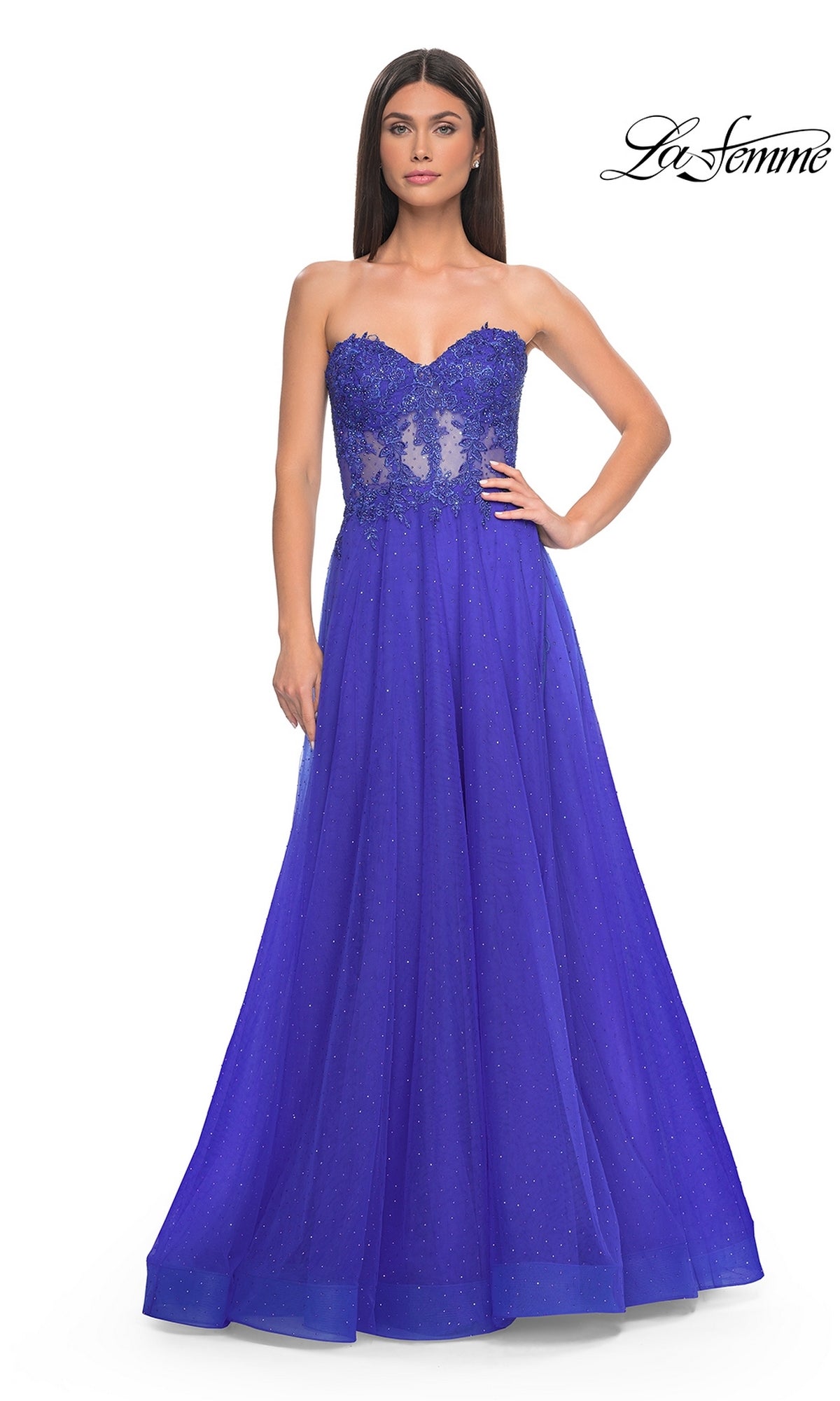 A woman wearing the La Femme Sheer-Waist Long A-Line Prom Dress 32313 in royal blue, featuring a strapless beaded lace bodice and a flowing skirt.