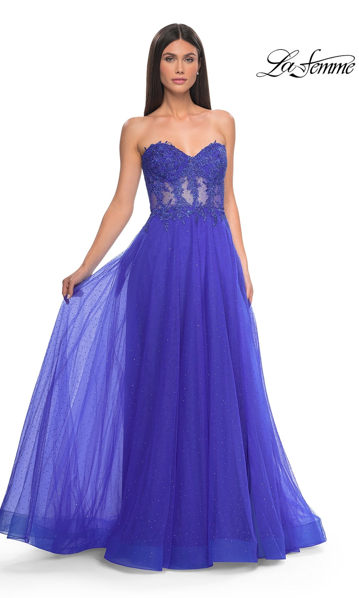 A woman wears the La Femme Sheer-Waist Long A-Line Prom Dress 32313, featuring a strapless royal blue beaded lace bodice and a full tulle skirt. The La Femme logo appears in the top right corner.