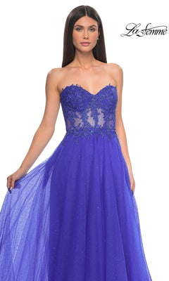Woman wears the La Femme Sheer-Waist Long A-Line Prom Dress 32313 in royal blue, featuring a strapless beaded lace bodice and flowy tulle skirt. The "La Femme" logo appears at the top right corner.