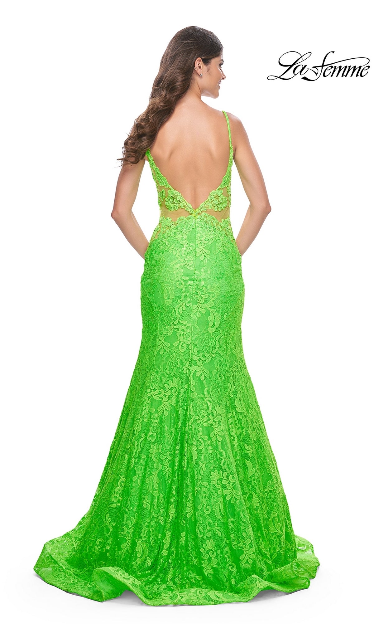 A woman faces away from the camera in the La Femme Bright Long Lace Mermaid Prom Dress 32314, featuring a vivid green color, deep scoop back, thin straps, and a flared mermaid silhouette for an elegant look.