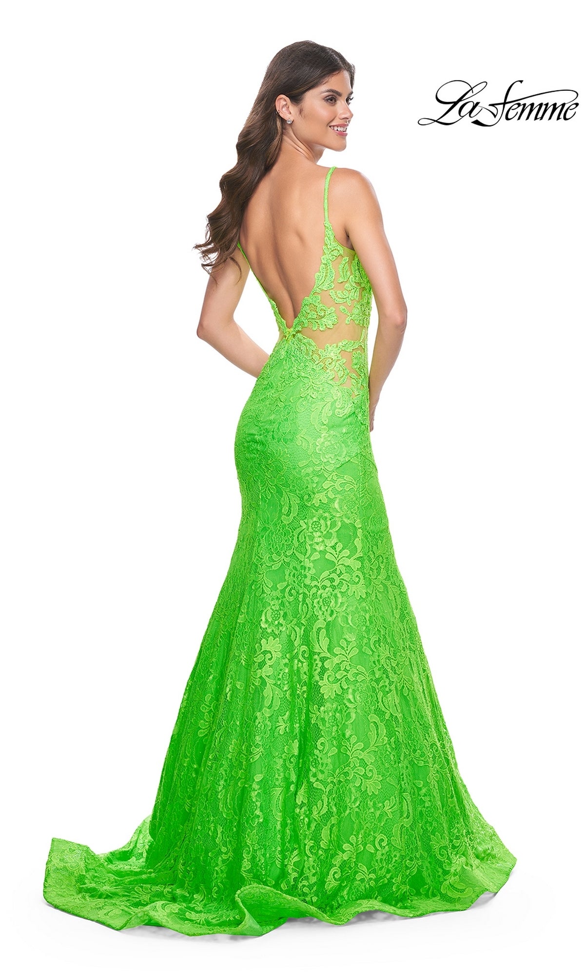 A woman stands against a white background, looking over her shoulder in the La Femme Bright Long Lace Mermaid Prom Dress 32314 with lace detailing and an open back.
