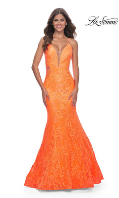 A woman wears the La Femme Bright Long Lace Mermaid Prom Dress 32314 in bright orange, featuring lace details, a mermaid silhouette, thin straps, a deep V-neckline, and a fitted bodice flaring at the hem. The La Femme logo appears in the top right corner.