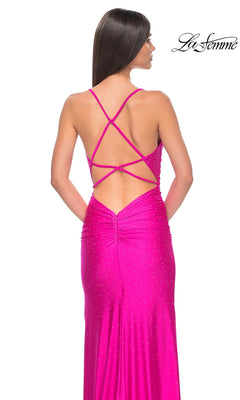 A woman wearing the La Femme Backless Long Beaded Prom Dress 32317—bright pink, with thin crisscross straps, sparkling embellishments, and an open back—is shown from behind.