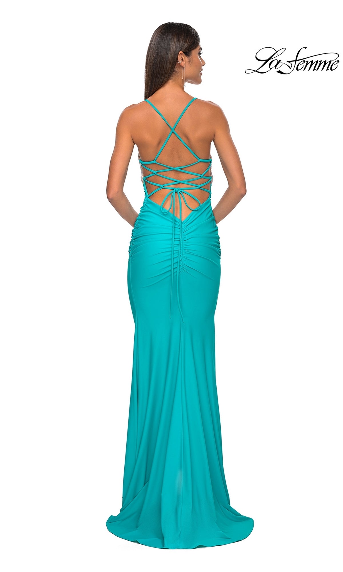 A woman in the La Femme Embellished-Bodice Long Prom Dress 32320, featuring a teal hue, ruched back, crisscross straps, and embellished bodice, poses with her back to the camera. 