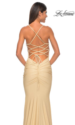 A woman is seen from behind wearing the La Femme Embellished-Bodice Long Prom Dress 32320 in beige, featuring crisscross lace-up straps and ruched details. The "La Femme" logo appears in the top right corner.